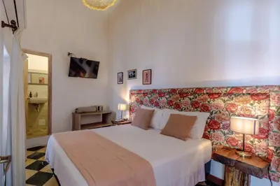 a bedroom with a large bed with a floral headboard at Bololá Hotel in Cartagena de Indias