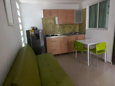 a kitchen with a green couch and a table and a refrigerator at Golden House Apartments - 2 Bedrooms in Barranquilla