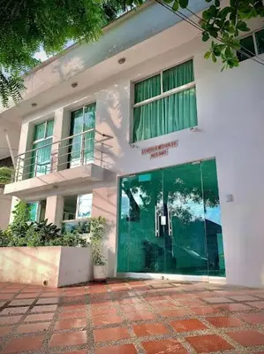 a white building with a green door in front of it at Golden House Apartments - 2 Bedrooms in Barranquilla