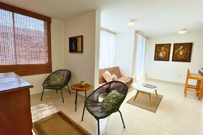 a living room with three chairs and a table at Apartmento En Miramar in Barranquilla
