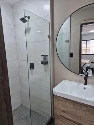 a bathroom with a shower and a sink and a mirror at Laureles del parque Loft in Barranquilla