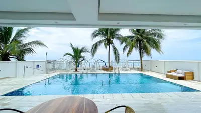 a swimming pool on top of a building with palm trees at Magico Apartamento Frente al Mar 3 Habitaciones TV52 in Coveñas