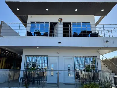 a house with a balcony with tables and chairs at Apartamentos el mochilero frente a la playa piso 2 apto 4 in Cartagena de Indias