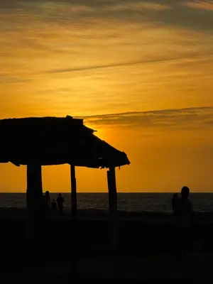 a group of people walking on the beach at sunset at Apartamentos el mochilero frente a la playa piso 2 apto 4 in Cartagena de Indias