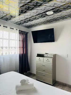 a bedroom with a bed and a tv on the ceiling at Apartamentos el mochilero frente a la playa piso 2 apto 4 in Cartagena de Indias