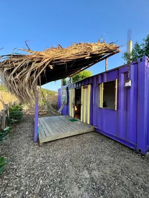 a purple house with a thatched roof at WIND en Mojarra Beach Aire acondicionado Habitación privada in Salina de Rey