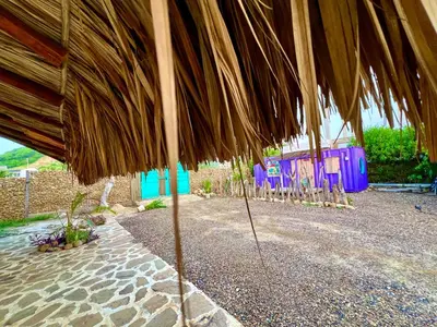 a large straw umbrella sitting on top of a patio at WIND en Mojarra Beach Aire acondicionado Habitación privada in Salina de Rey