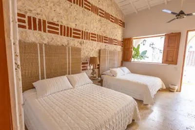 a bedroom with two beds and a window at Casa Beatriz Luxury Colonial House in Cartagena de Indias