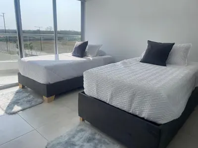 two beds in a room with a large window at Moderno Apartamento en Cartagena in Cartagena de Indias