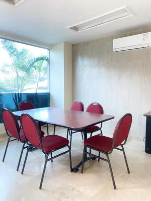 a conference room with a table and red chairs at Hotel Continental Plaza Barranquilla in Barranquilla