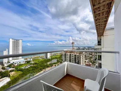a balcony with two chairs and a view of the ocean at Apartamento Aqua in Cartagena de Indias