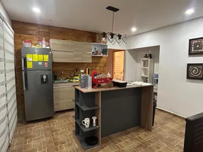 a kitchen with a refrigerator and a counter in it at Casa de campo con piscina, aire acondicionado, estacionamiento privado con BBQ in Barranquilla