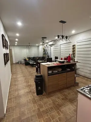 a kitchen and living room with a counter and a table at Casa de campo con piscina, aire acondicionado, estacionamiento privado con BBQ in Barranquilla