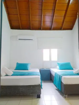 two beds in a room with wooden ceilings at Apto Centro Historico Quero in Cartagena de Indias