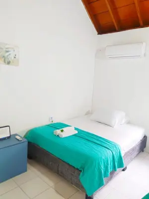 a bedroom with a bed with a green blanket at Apto Centro Historico Quero in Cartagena de Indias