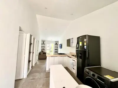 a kitchen with a black refrigerator and white cabinets at Apartamento en ciudad amurallada centro histórico Cartagena de Indias, Colombia in Cartagena de Indias