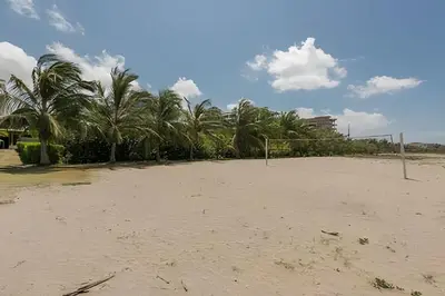 an empty volley ball court on a beach with palm trees at Lujoso con acceso directo a la Playa in Cartagena de Indias