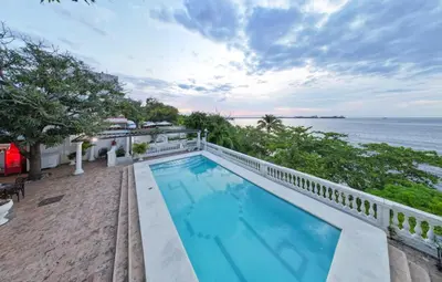 an outdoor swimming pool with a view of the ocean at Casa de playa Vistamare in Santa Marta
