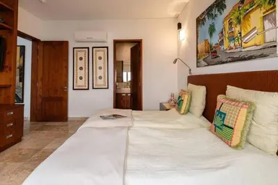 a bedroom with a large white bed with pillows at Luxury Apartment Private Pool & Rooftop Jacuzzi in Cartagena de Indias