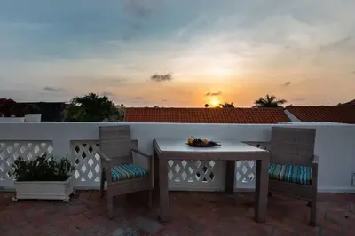 a table and chairs on a patio with the sunset at Luxury Apartment Private Pool & Rooftop Jacuzzi in Cartagena de Indias