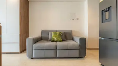 a gray chair with a pillow in a living room at Suite con daybed piso 16 y balcón panorámico CB1638 in Cartagena de Indias