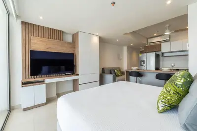 a bedroom with a large bed and a kitchen at Suite con daybed piso 16 y balcón panorámico CB1638 in Cartagena de Indias