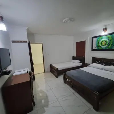 a bedroom with two beds and a flat screen tv at Hotel Cartagena Comfort in Cartagena de Indias