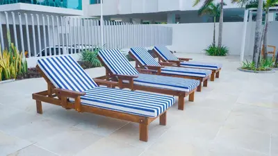 a row of wooden lounge chairs on a patio at Magico Apartamento Frente al Mar 4 Habitaciones BM83 in Coveñas