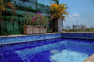 a swimming pool with two potted plants on a building at Loft with view 7 rooms in Cartagena de Indias