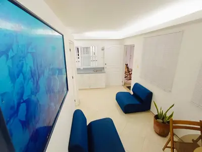 a living room with blue chairs and a flat screen tv at Acogedores Apartaestudios en Getsemaní in Cartagena de Indias