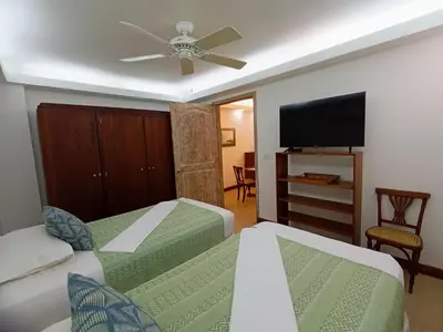 a bedroom with two beds and a flat screen tv at Acogedores Apartaestudios en Getsemaní in Cartagena de Indias