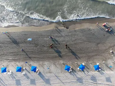 an overhead view of a beach with blue umbrellas at Condominio frente al mar con acceso directo a la playa Morros IO in Cartagena de Indias