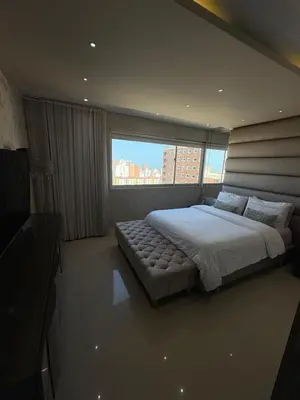 a bedroom with a large bed and a large window at Apto moderno frente CC Buenavista, lujo y vistas in Barranquilla