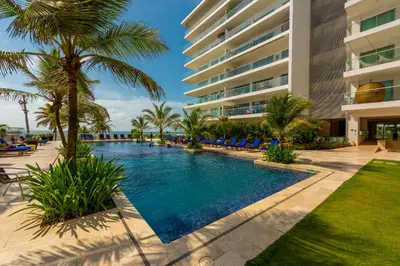 a resort swimming pool with palm trees and a building at Morros Epic 216 in Cartagena de Indias