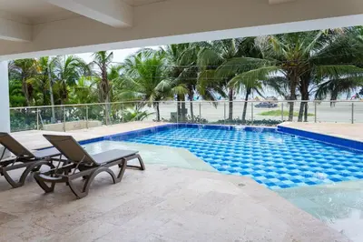 a swimming pool with two lounge chairs next to it at Apartamento 1 dormitorio Morros. Vista Mar y Salida Playa in Cartagena de Indias