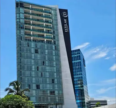 a tall building with a palm tree in front of it at Apartamento en el Hotel Estelar in Barranquilla
