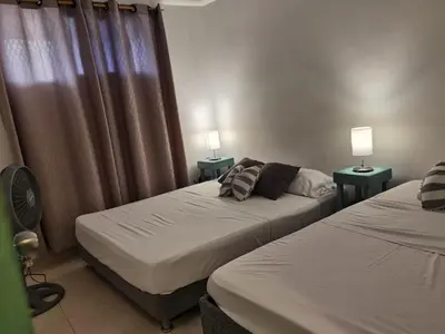 two beds in a room with two lamps and curtains at Apartamentos Santori in Cartagena de Indias
