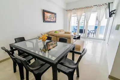 a dining room and living room with a glass table and chairs at Apartamento Unik Cartagena Edificio Poseidón in Cartagena de Indias