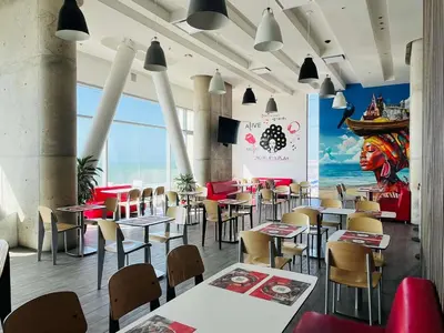 a restaurant with tables and chairs and a large window at ibis Cartagena Marbella in Cartagena de Indias