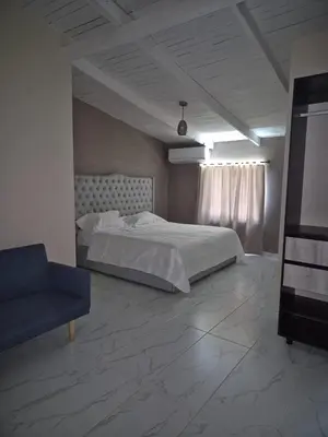 a large bedroom with a bed and a couch at Laureles del parque loft in Barranquilla