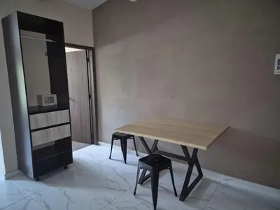 a wooden table in a room with a stool at Laureles del parque loft in Barranquilla