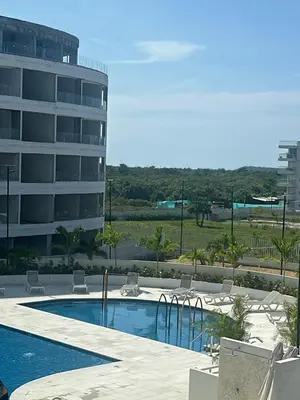 a swimming pool with chairs and a building at Cozy apartment Brand new in Cartagena de Indias