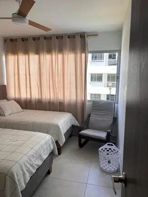 a bedroom with two beds and a chair and a window at Cozy apartment Brand new in Cartagena de Indias