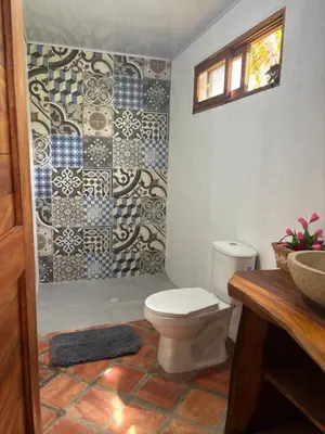 a bathroom with a toilet and a mosaic shower at Casa Arrecife San Bernardo del Viento in San Bernardo del Viento