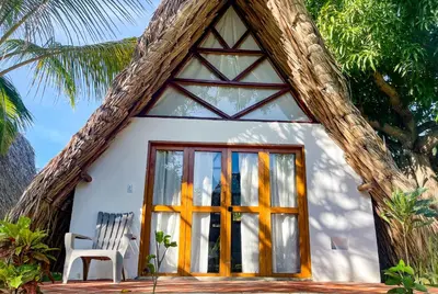 a small house with a window and a chair at Casa Arrecife San Bernardo del Viento in San Bernardo del Viento