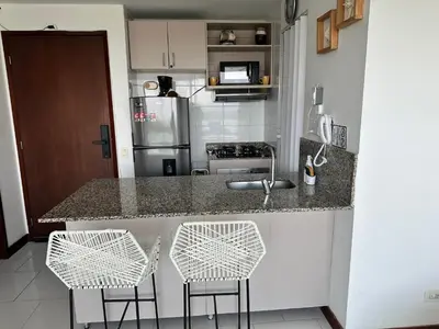 a kitchen with a counter with two stools and a sink at Morros la boquilla in Cartagena de Indias