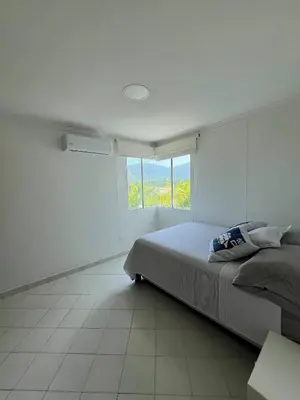 a white bedroom with a bed and a window at Unwind in Santa Martas Oceanfront Retreat in Playa Dormida