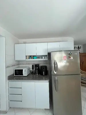 a kitchen with a stainless steel refrigerator and white cabinets at Unwind in Santa Martas Oceanfront Retreat in Playa Dormida