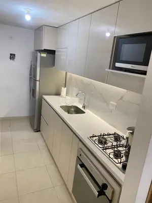 a white kitchen with a sink and a stove at Habitación en Villa Carolina con aire in Barranquilla