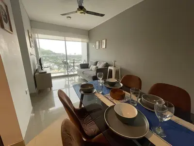 a dining room with a table and chairs and a couch at PISO 19 Mirador Oasis Costero in Cartagena de Indias